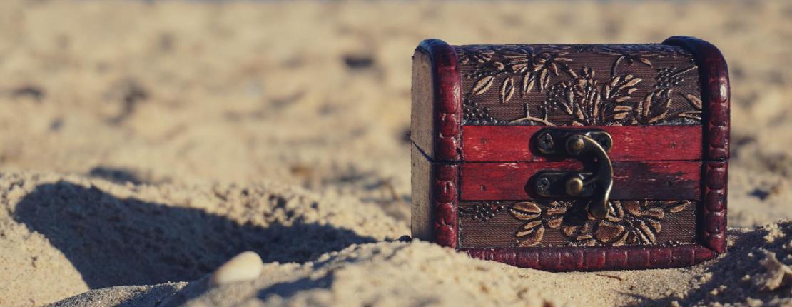 Red and Black Wooden Chest on White Sand